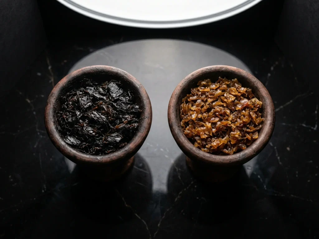 A side-by-side view of two clay bowls, beautifully highlighting the rich, deep color of dark leaf shisha on the left compared to the much lighter, golden blonde leaf on the right.